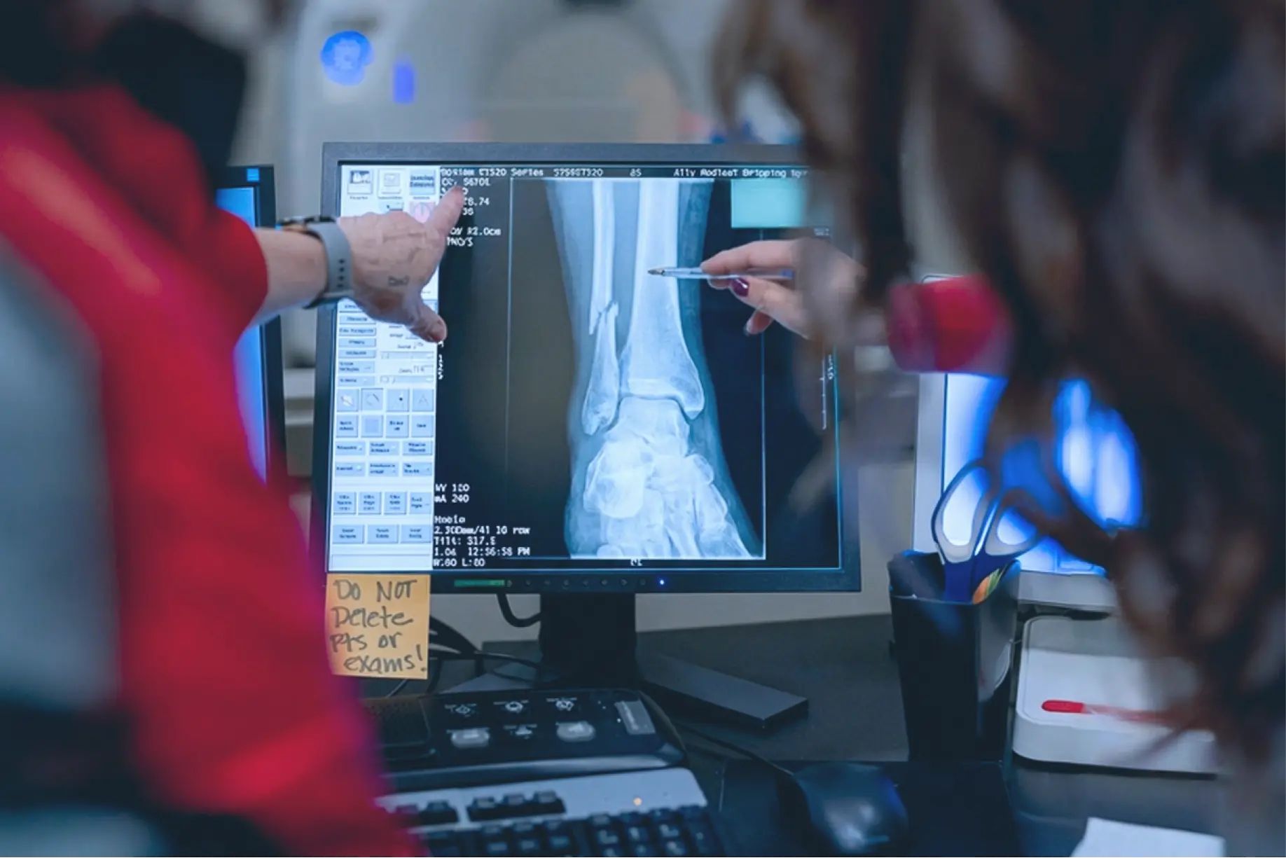 Two Ally Medical professionals examine an x-ray of an ankle